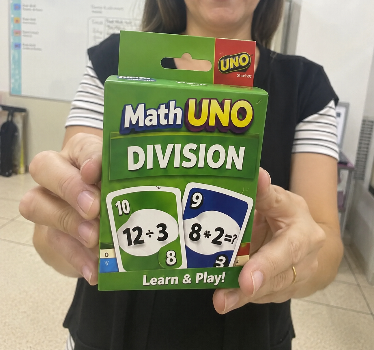 Teacher holding the Math UNO Division deck